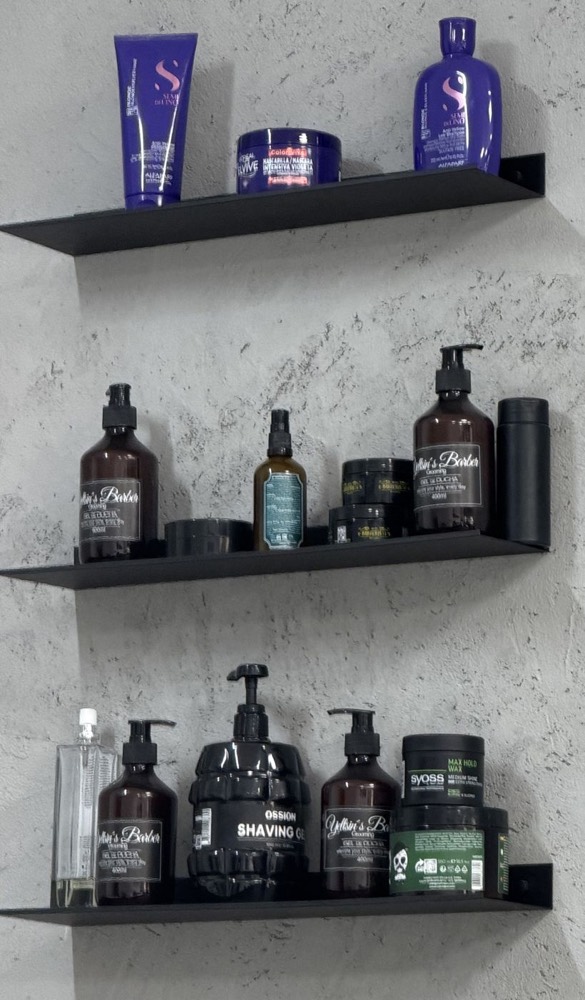 Estantes con la línea Yeltsin&rsquo;s Barber Grooming sobre la pared de hormigón